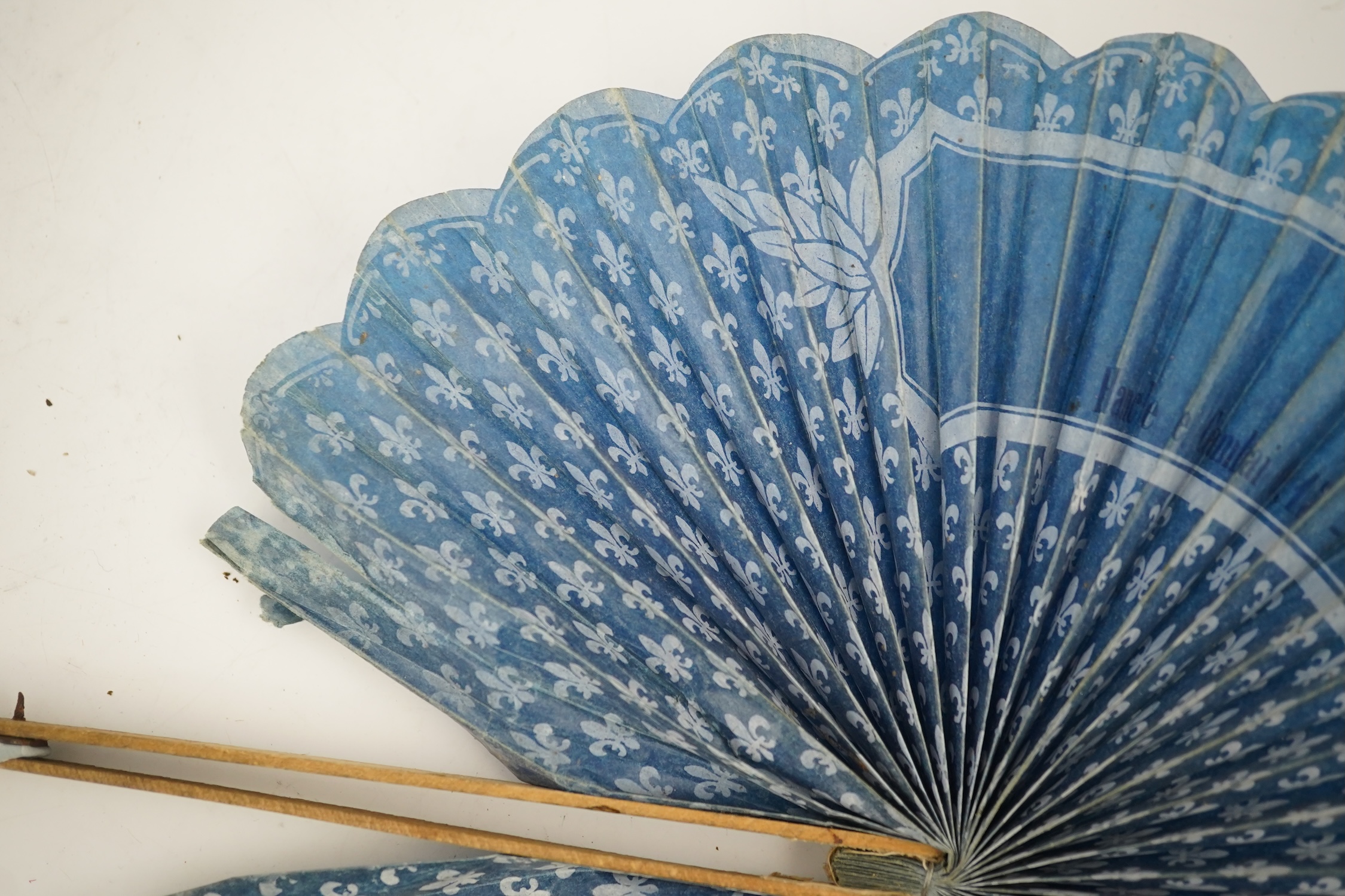 Three novelty fans with a mixed Brussels lace fan and black lace fan, a small language of love in flowers fan, a paper windmill advertising French Café fan, a carved cream Bakelite fan, a black and gilt, lace and sequin